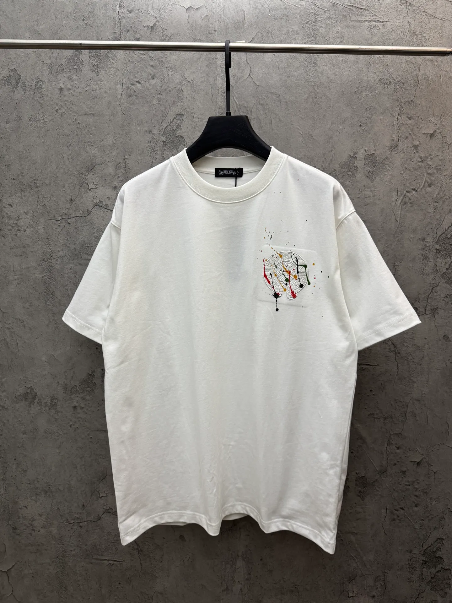 P190 top version, real shot without P, ​​different from market currency) 𝗖𝗵𝗿𝗼𝗺𝗲 𝗛𝗲𝗮𝗿𝘁𝘀/Croxin 2026 spring new original single counter American leather embroidery plus painted inkjet couple short sleeves 👑The highest version! Customized fabric 300 grams, best-selling model at the counter, very comfortable to wear. Accessories: original molded and authenticated collar label ➕ 100% silk wash water label. Genuine purchase-grade original hangtag➕matching hanging rope➕3D hanging beads➕original packaging bag. Craftsmanship: The original version has consistent wiring! The highest version of the armhole matching technique! Color: White Black Size: S M L XL Style No.: 26-2030